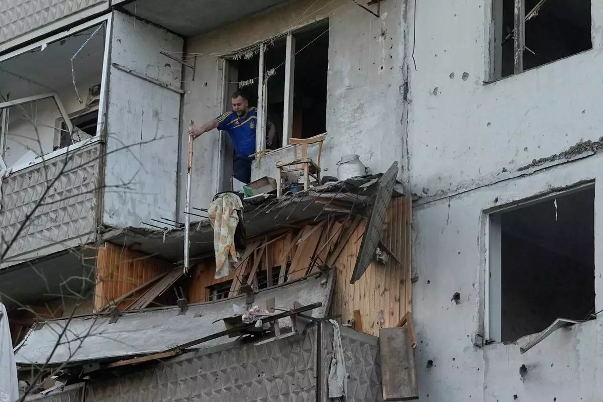 A man clears debris in his apartment building damaged after Russian missile strike that hit in Kyiv, Ukraine, Tuesday, June 2, 2026. (AP Photo/Efrem Lukatsky)