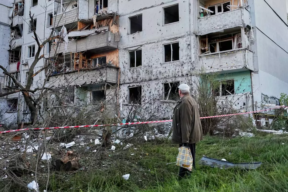 A resident looks at the site of a Russian missile strike that hit a residential building in Kyiv, Ukraine, Tuesday, June 2, 2026. (AP Photo/Efrem Lukatsky)