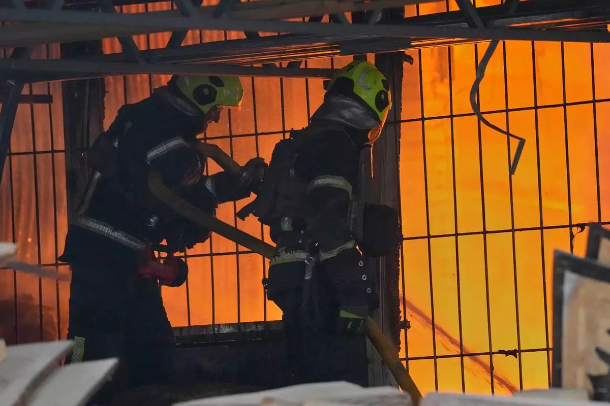 Firefighters work on the site of a burning building after a Russian missile attack in Kyiv, Ukraine, Tuesday, June 2, 2026. (AP Photo/Efrem Lukatsky)