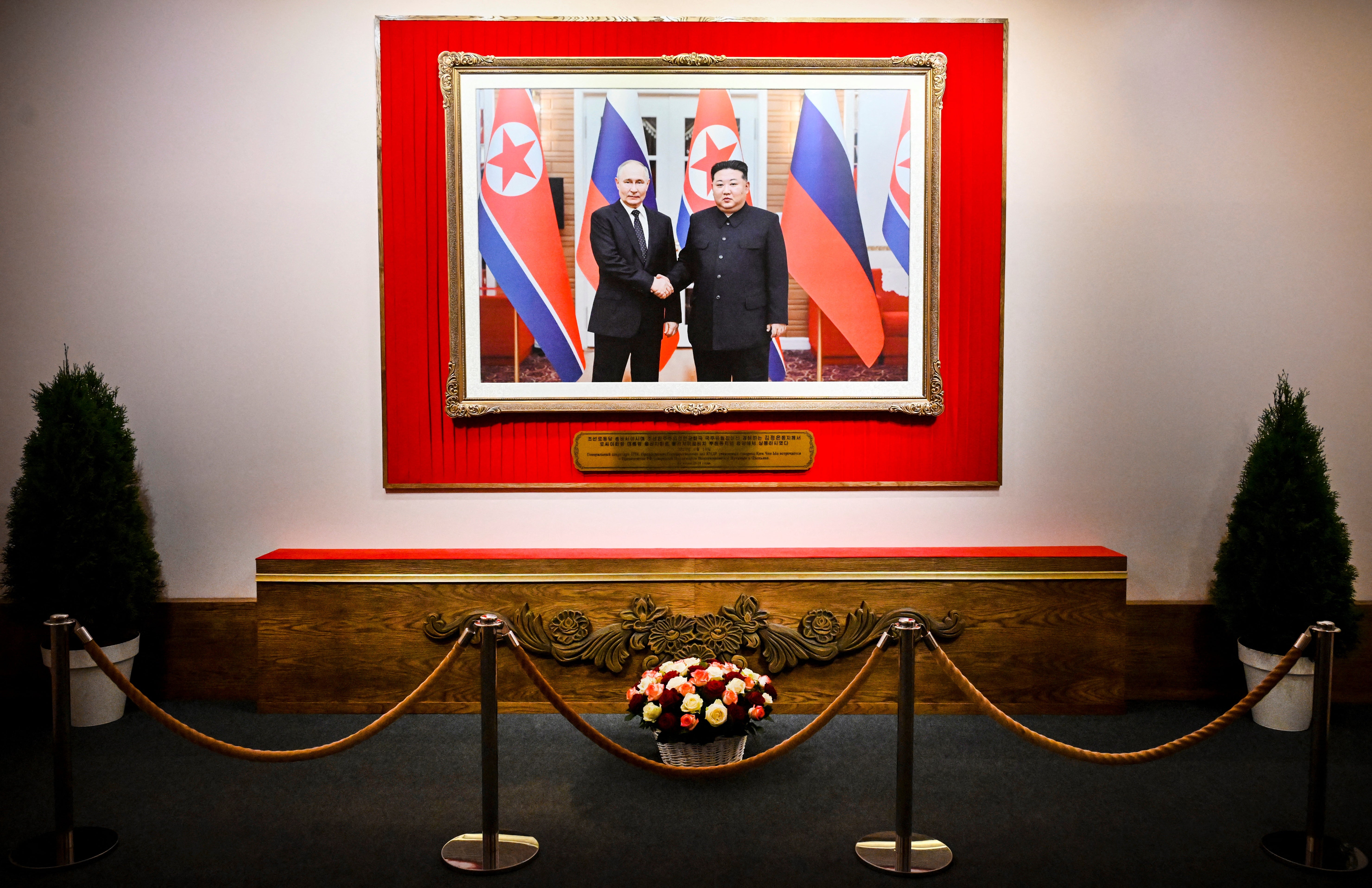 A photo of Putin and North Korean leader Kim Jong Un meeting each other in Pyongyang on June 19, 2024, is seen during North Korean arts exhibition in Moscow