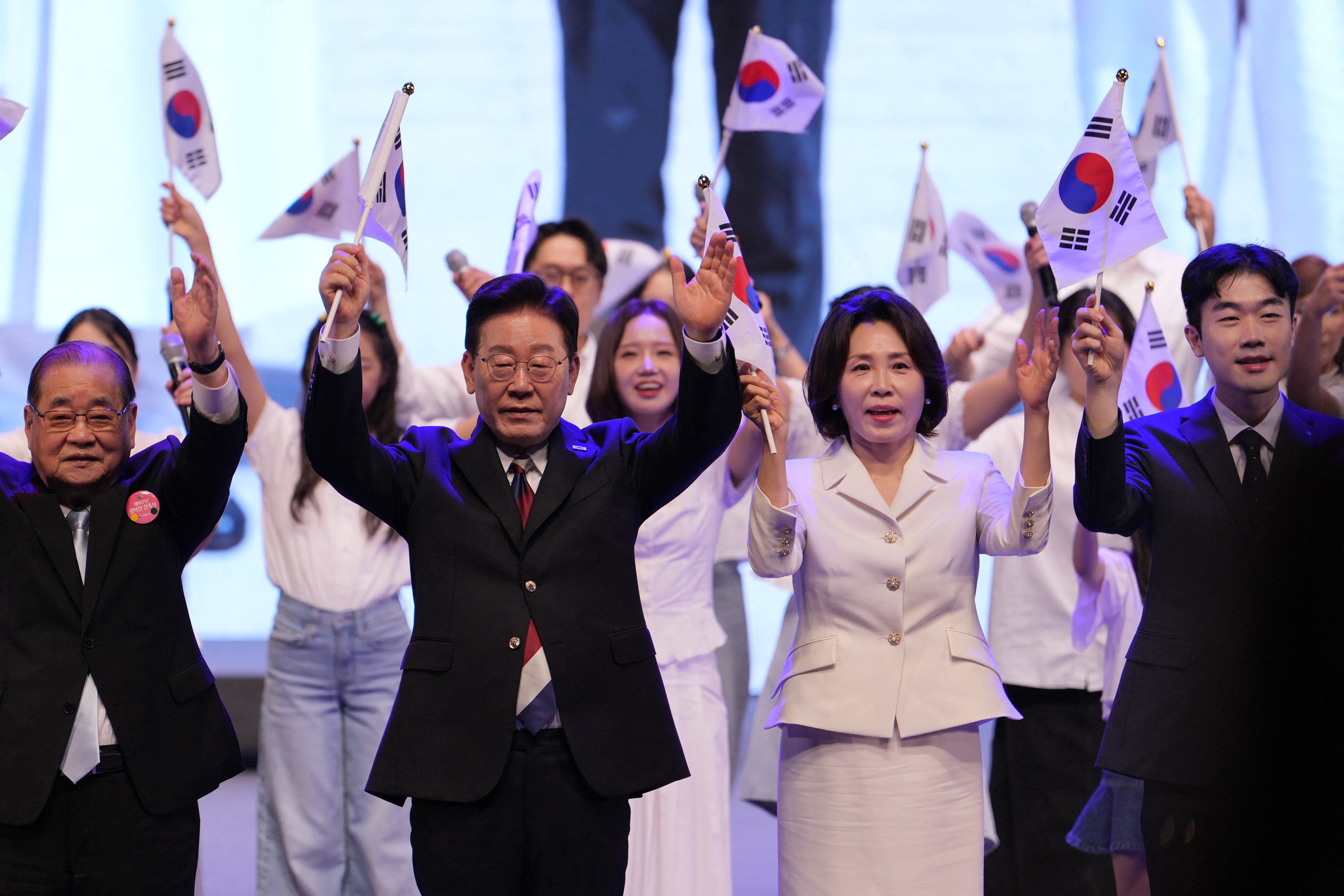 Lee Jae Myung and his wife Kim Hea Kyung wave the national flag