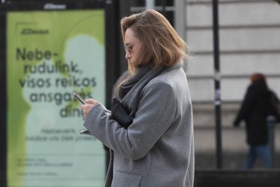 Moteris su išmaniuoju telefonu