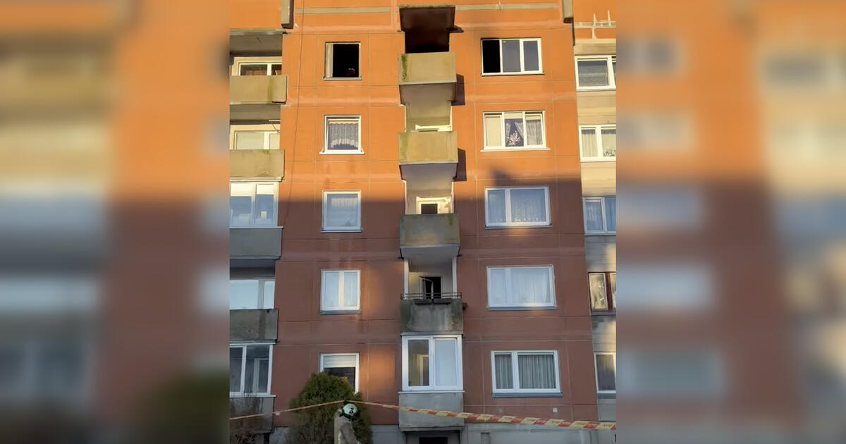 moteris pro langą iš penktojo aukšto šoko ugniagesiams žengiant į degantį butą