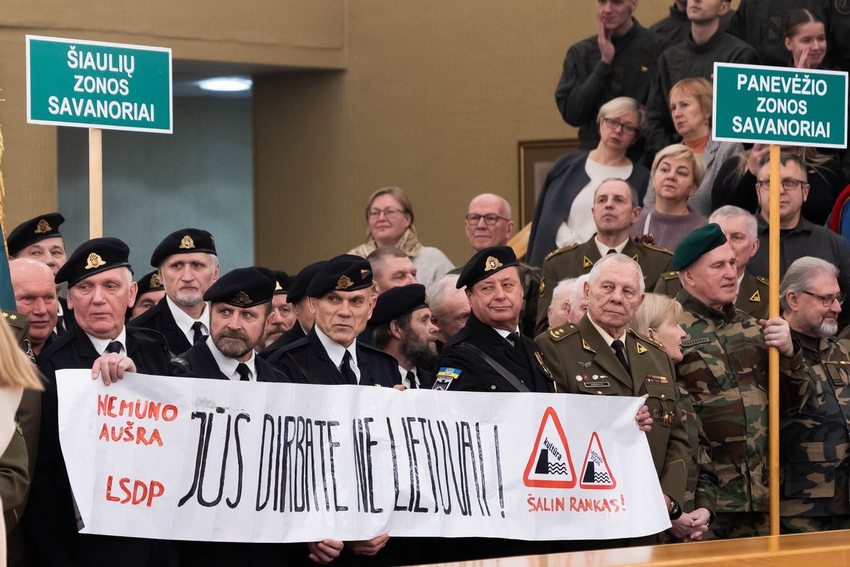 Olekui sakant kalbą Laisvės gynėjų susitikime, iškeltas plakatas „Jūs dirbate ne Lietuvai“ - Delfi