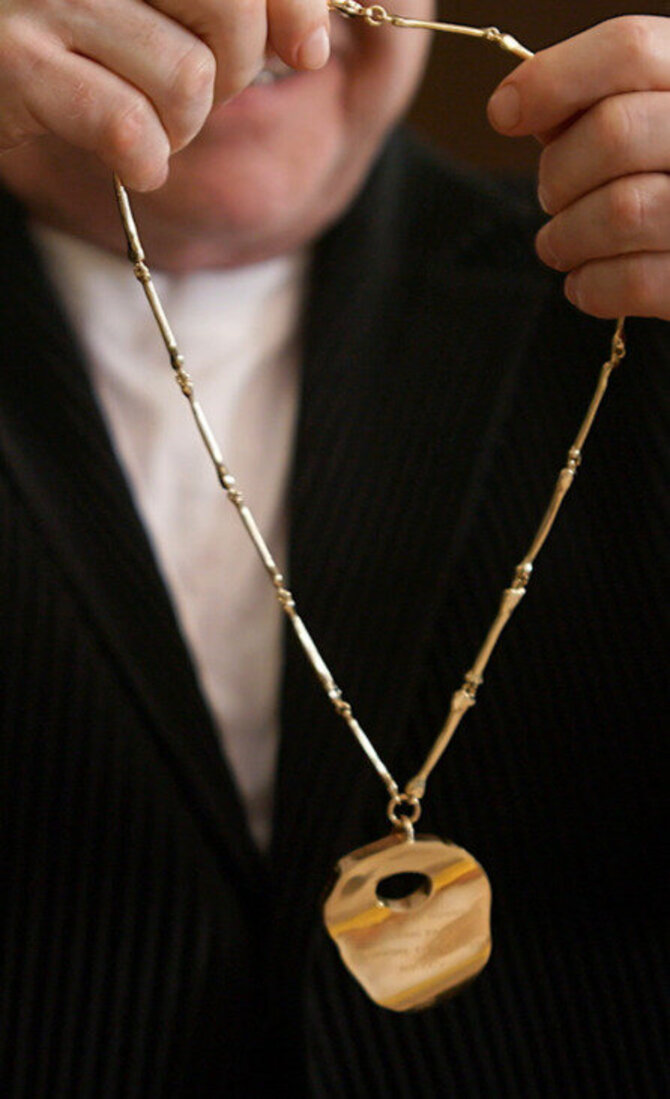 Stop kadras/Papuošalas su Eltono Johno kaulu