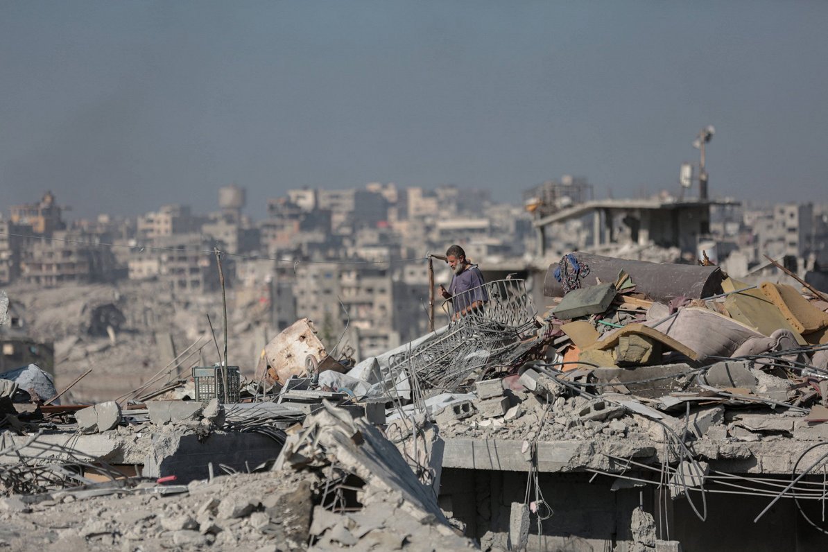 Cilvēks ēkas drupās kara sagrautajā Gazas joslā