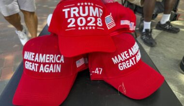 Sarkanās cepures ar nagu ar uzrakstiem "Trump 2028" un "Make America Great Again"...
