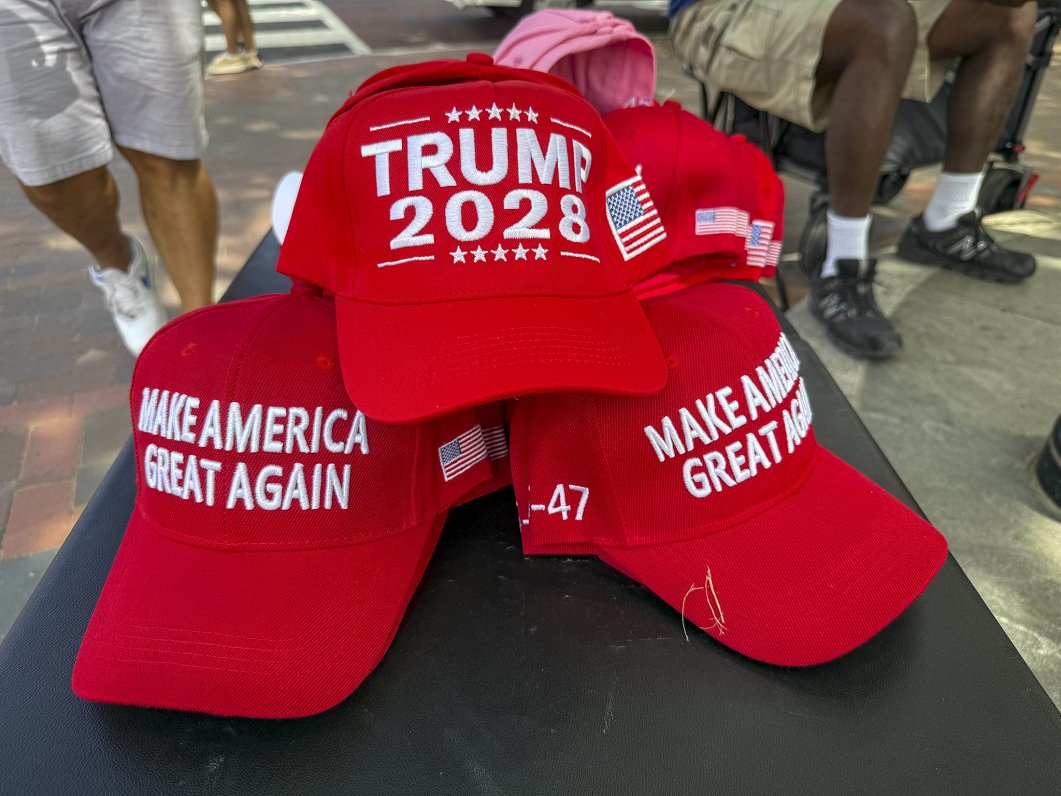 Sarkanās cepures ar nagu ar uzrakstiem "Trump 2028" un "Make America Great Again"...