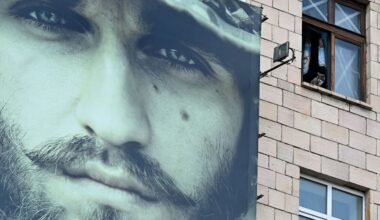 Dzīvojamā ēka, uz kuras izvietots liels &quot;Azovas&quot; brigādes vervēšanas plakāts.