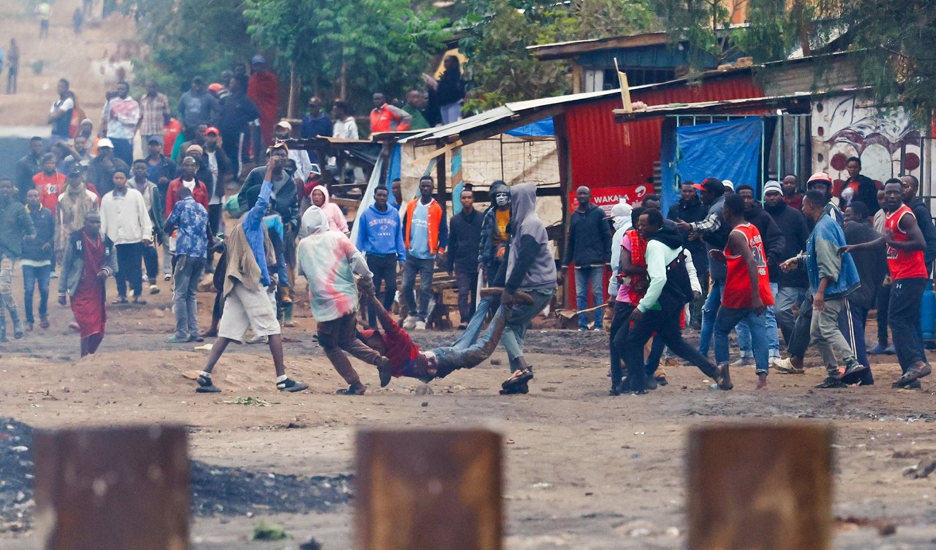 Tanzāniešu protestētāji pie Kenijas robežas nes nošautā biedra līķi