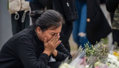 Sieviete 30. novembrī sēro pie ugunsgrēka izpostītā māju kompleksa Honkongā