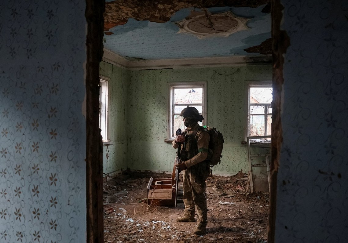 Ukraiņu karavīrs karadarbībā izpostītā namā Doneckas apgabalā