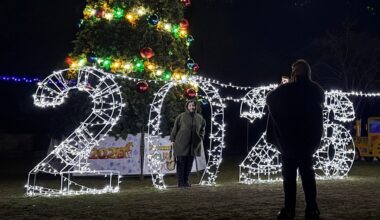 Ukrainas pilsētā Zaporižjā cilvēki fotografējas pie Ziemassvētku egles