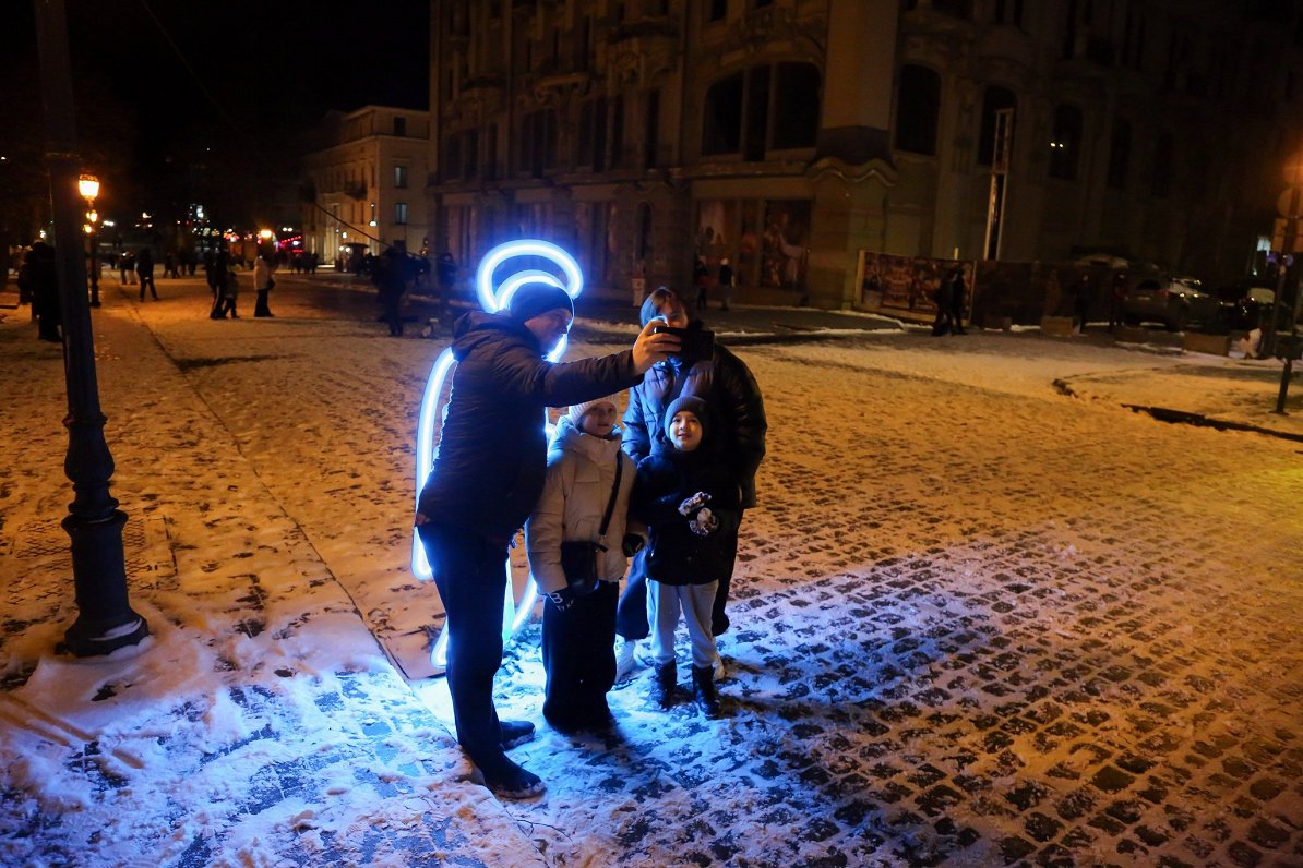 Ukrainas pilsētā Odesā ģimene fotografējas pie eņģeļa figūras