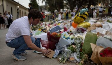 Cilvēki noliek ziedu pie Bondi pludmales slaktiņa vietas. Sidneja, Austrālija. 2025. gada decembris.