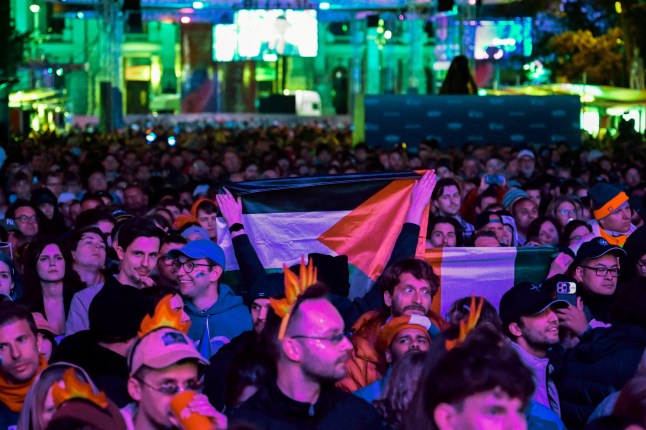 A person holds a Palestinian flag as people attend a public viewing of the Grand Final of the 2026 Eurovision Song Contest in Vienna, Austria, May 16, 2026. REUTERS/Elisabeth Mandl