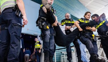 De politie verwijdert een demonstrant uit het auditorium van de Technische Universiteit Eindhoven