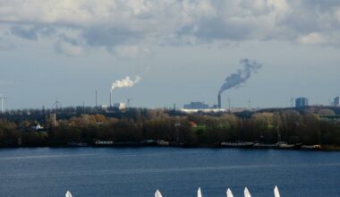 Zeilboten in Noord-Holland, met op de achtergrond fabrieken en windmolens