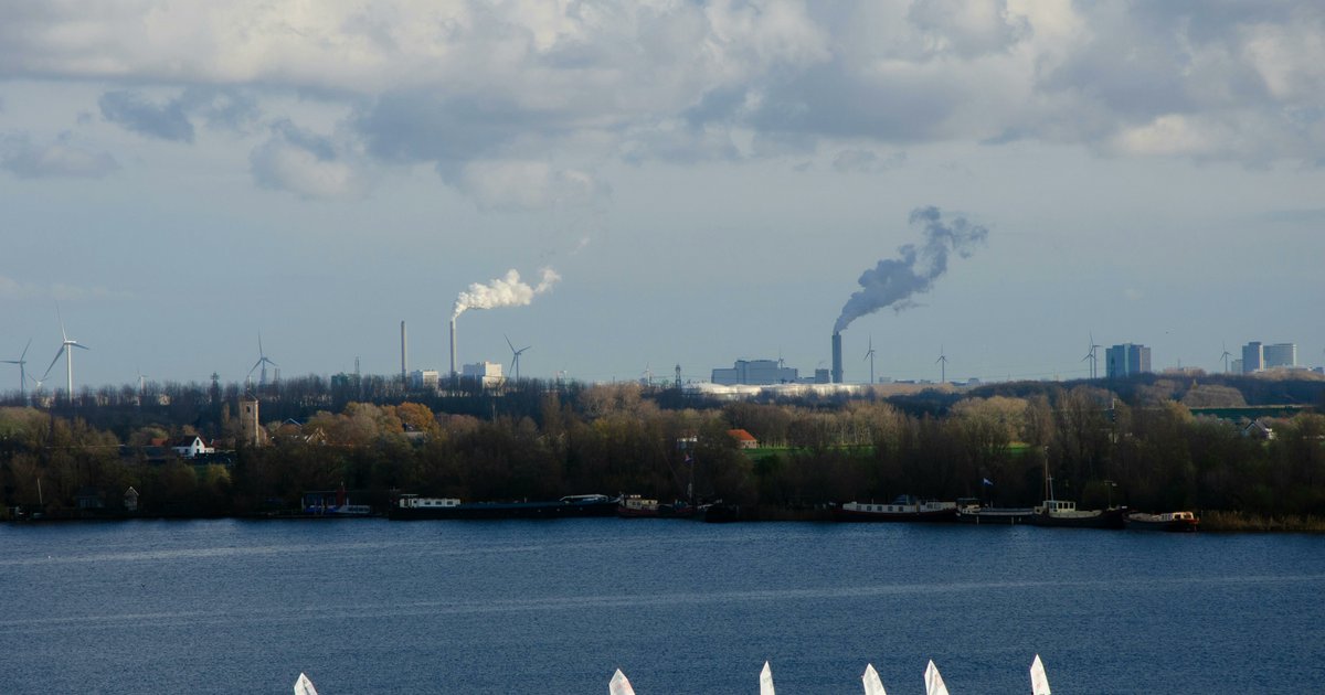 Zeilboten in Noord-Holland, met op de achtergrond fabrieken en windmolens