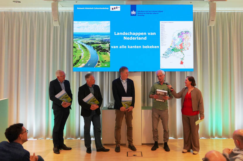 overhandiging eerste exemplaren boek op podium