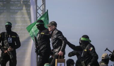 Hamas-strijders dragen de Israëlische gijzelaar Keith Siegel over aan het Rode Kruis.
