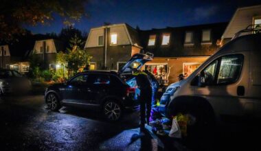 Agenten doorzoeken een huis en twee wagens (foto: SQ Vision).
