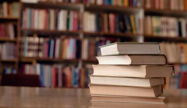 Een stapel boeken op een tafel, op de achtergrond boekenkasten.