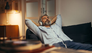 Een man luistert met koptelefoon op naar muziek, bijvoorbeeld de Klassieke Top 400.