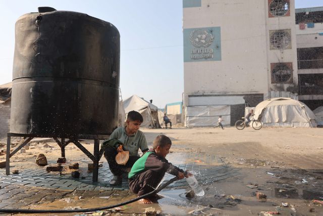 Een jongen vult een plastic fles met waterin een kamp voor ontheemden in Gaza-Stad. 