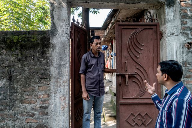 De 37-jarige maatschappelijk activist Amjad Alam bespreekt in Kishanganj met een buurtbewoner of diens naam op de definitieve kiezerslijst staat.
