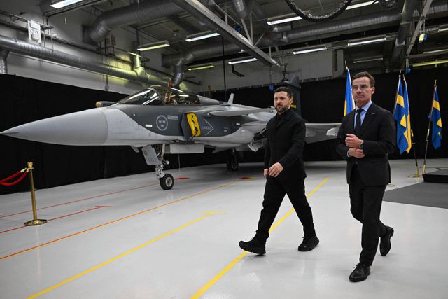 De Zweedse premier Ulf Kristersson (r.) en de Oekraïense president Volodymyr Zelensky voor een Gripen gevechtsvliegtuig, op 22 oktober. 