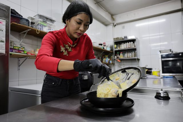 De Venezolaanse Yolisbell Rodríguez aan het werk in restaurant Candy dat ze samen met haar Surinaamse echtgenoot Ameeth Ragnoenath runt. 