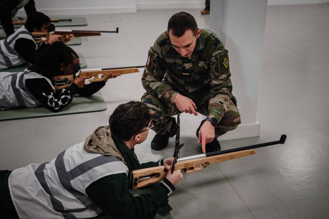 Een militair instructeur begeleidt deelnemers tijdens een laser-schiettraining in het kader van de Dag van Defensie en Burgerschap in Fort de Montrouge in Arcueil, ten zuiden van Parijs.