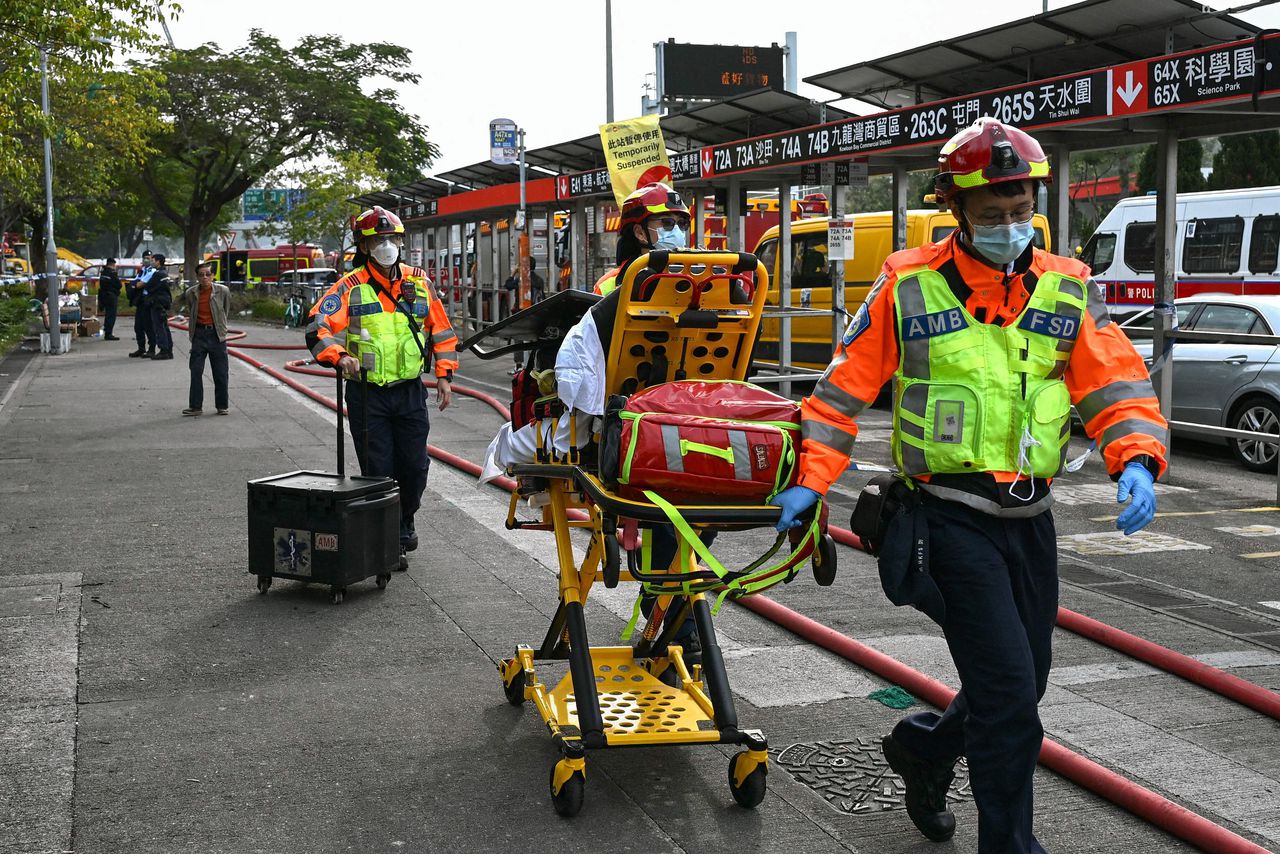 Paramedics leave the still burning Wang Fuk Court residential estate in Hong Kong's Tai Po district on November 27, 2025. Firefighters were still dousing a devastating fire on November 27 which ripped through a Hong Kong high-rise complex, killing at least 44 people and leaving hundreds missing according to authorities.