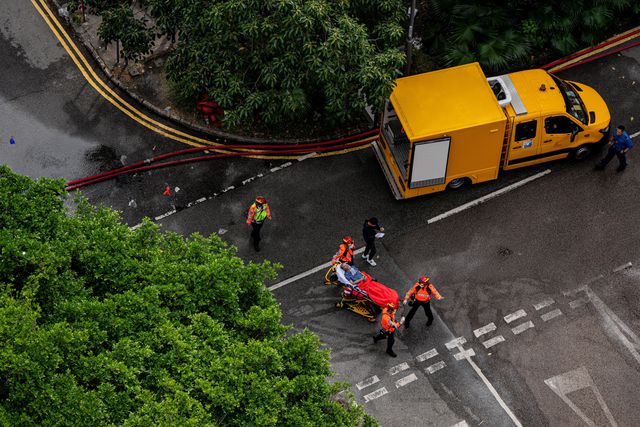 epa12551822 Rescuers load an injured person onto an ambulance (out of frame) during an apartment fire in the Tai Po district of Hong Kong, China, 27 November 2025. The fire, which started on 26 November, has killed at least 44 people, and left 279 missing. EPA/LEUNG MAN HEI