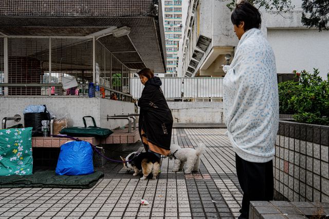 Ontheemde bewoners kijken toe tijdens een brand in een appartement in de wijk Tai Po in Hongkong, 27 november 2025.