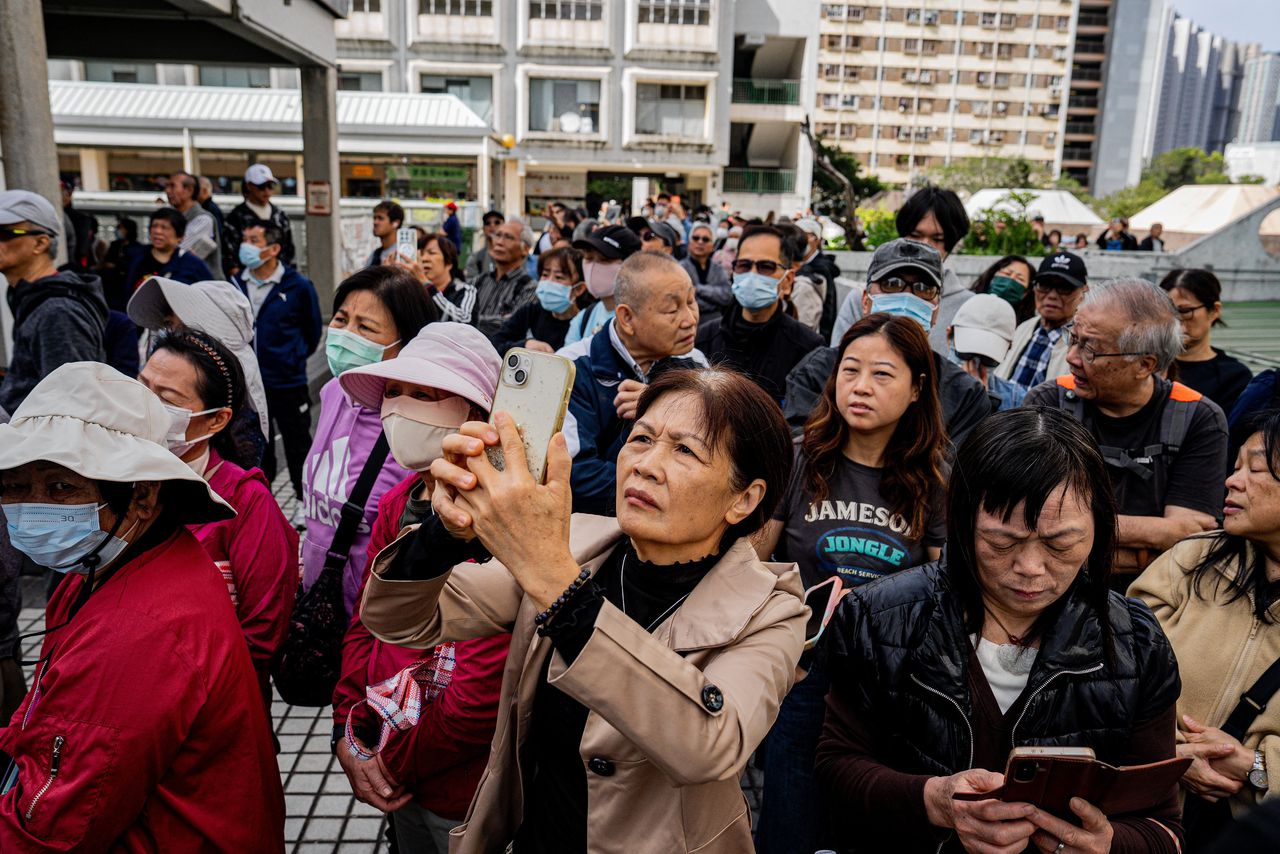 epa12551820 People watch an apartment fire in the Tai Po district of Hong Kong, China, 27 November 2025. The fire, which started on 26 November, has killed at least 44 people, and left 279 missing.