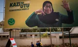 Schoolkinderen lopen langs een verkiezingsbord van de Tanzaniaanse presidentskandidaat Samia Suluhu Hassan van de regeringspartij Chama Cha Mapinduzi, in  de Tanzaniaanse stad Arusha.