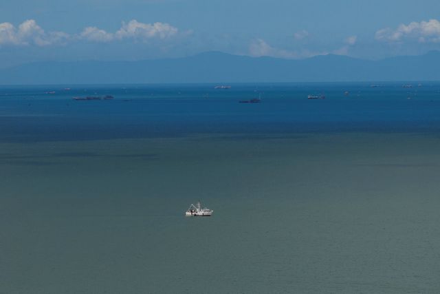Een vissersboot ligt voor anker bij de Venezolaanse kust, op de achtergrond Trinidad & Tobago. 