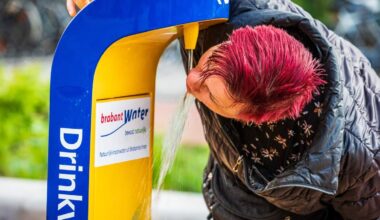 Een mevrouw die aan het drinken is bij een openbaar watertappunt.