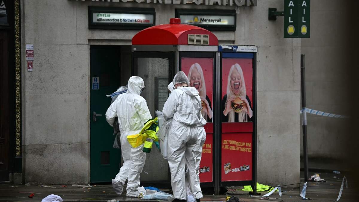 Mannen in witte pakken onderzoeken de plaats delict.