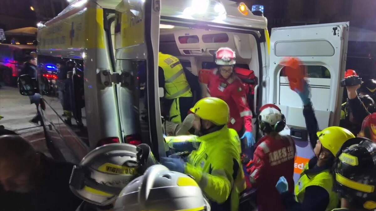 Reddingswerkers vervoeren de gewonde bouwvakkers van de ingestorte toren in Rome naar het ziekenhuis.