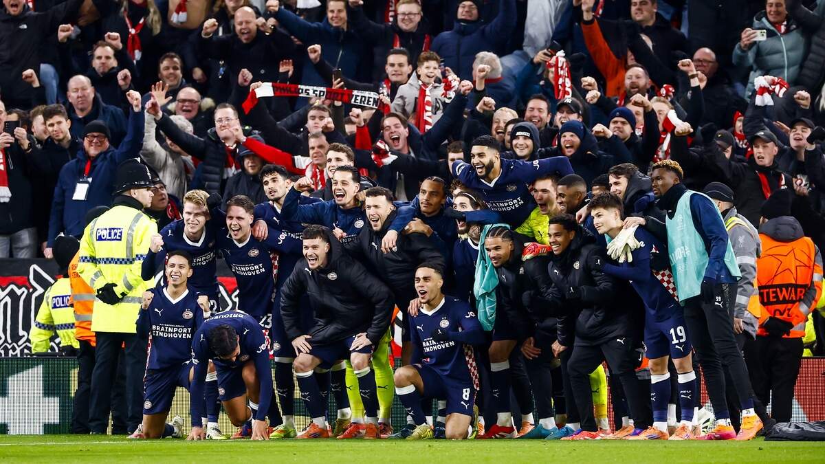 De spelers van PSV maken een groepsfoto bij het uitvak na de sensationele overwinning op Anfield.