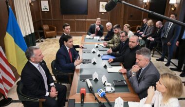 De delegaties van Oekraïne en de Verenigde Staten zitten om tafel.