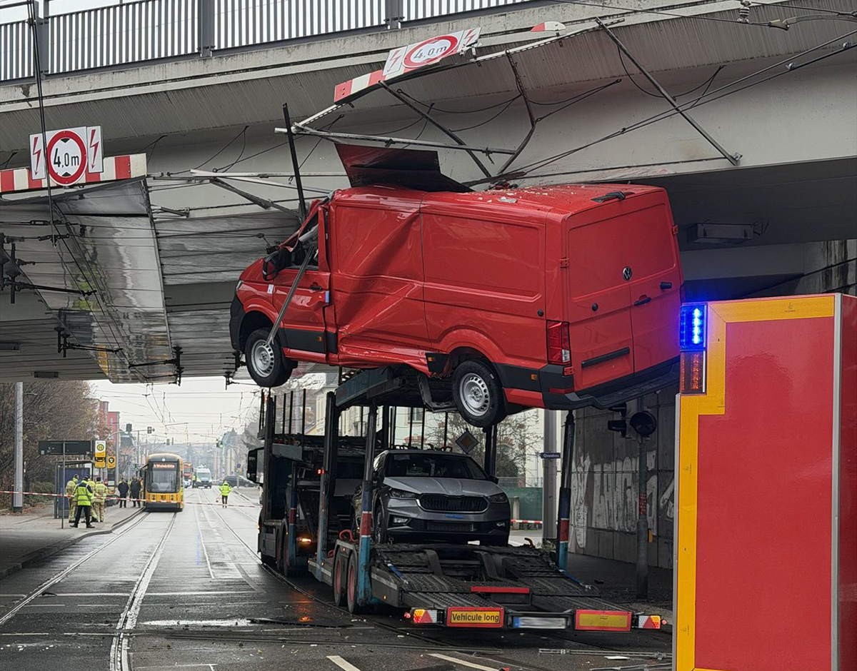 Autotransporter blijft steken onder brug in Dresden: bovenleiding tram beschadigd