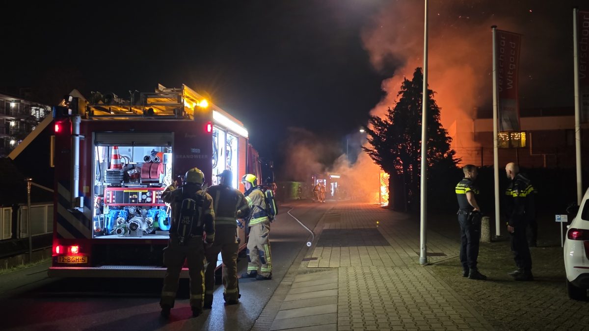 Heg in brand naast bedrijfspand; brandweer schaalt op - ZHZ Actueel