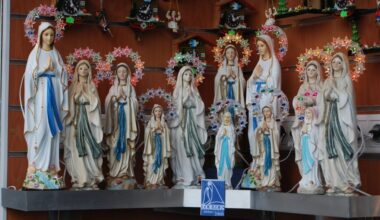 Stenen beeldjes van Maria, gekleed in wit en blauw.