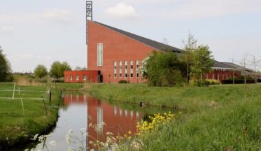 Groot kerkgebouw in groenrijke omgeving.