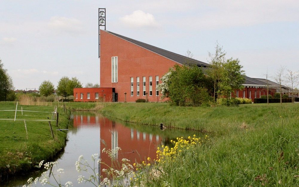 Groot kerkgebouw in groenrijke omgeving.