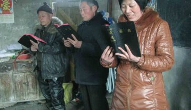 Twee mannen en een vrouw staan naast elkaar en lezen in de Bijbel.
